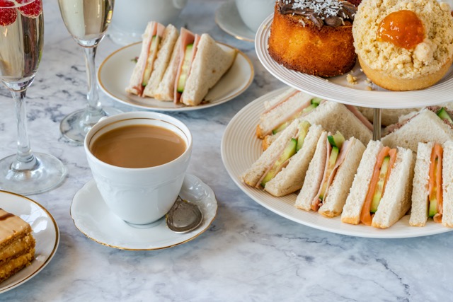 tea sandwhiches and a tea cup on a table