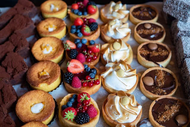 An above view of small tarts, chocolate, fruit, lemon and more yum