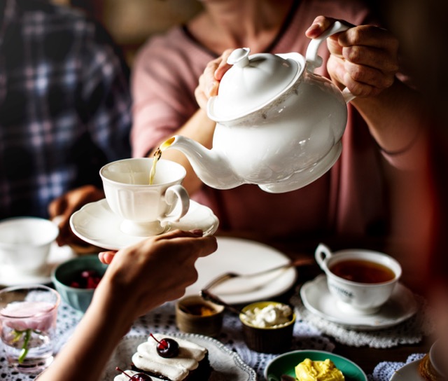table set with tea cups, tea pot and food